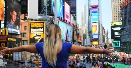 Au pair con le braccia aperte a Times Square