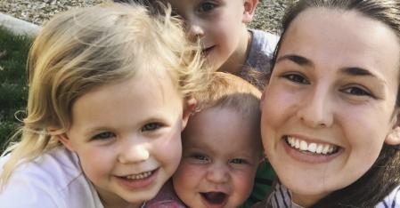Au pair con tre bambini piccoli in braccio