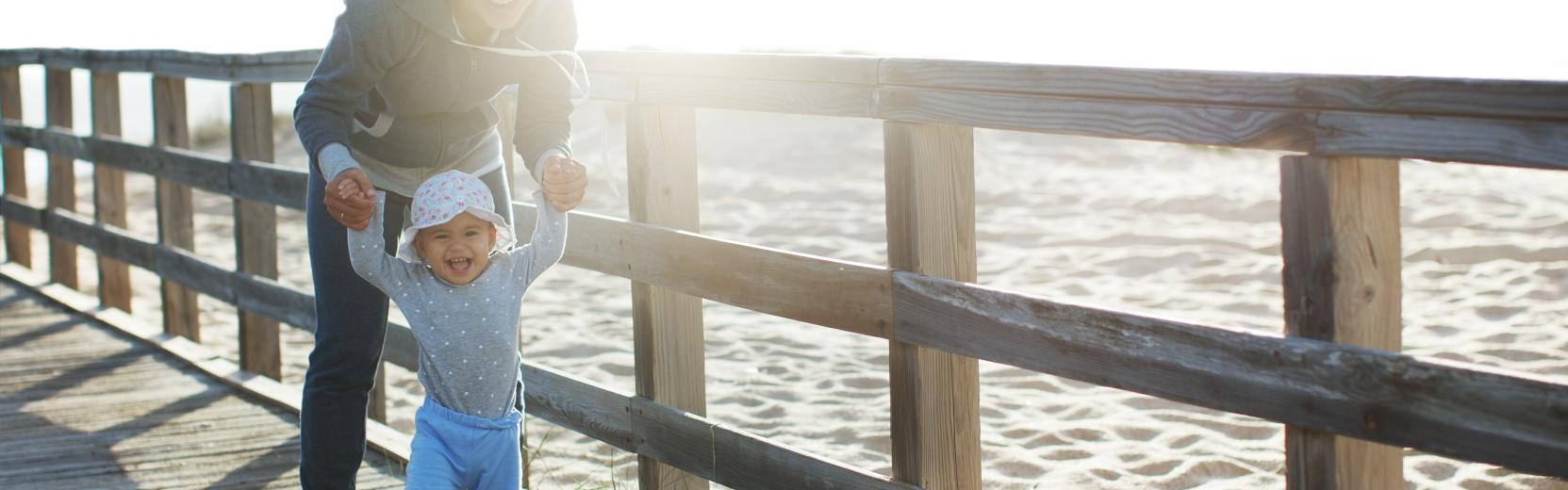 I primi passi dei compiti di un au pair ragazza alla pari con bambino sulla spiaggia