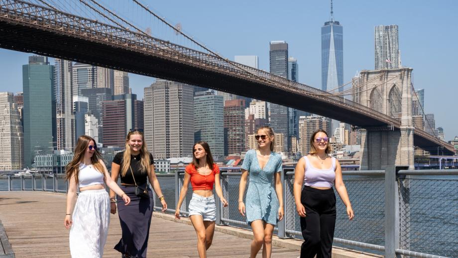 gruppo di cinque au pair che camminano vicino al Brooklyn Bridge