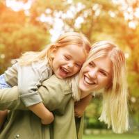 Ragazza alla pari con bambino sulle spalle